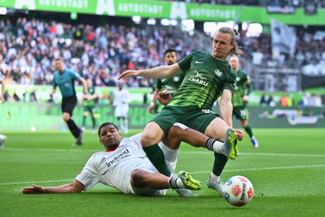 11 April 2026, Lower Saxony, Wolfsburg: Wolfsburg's Patrick Wimmer (R) Eintracht Frankfurt's Aurele Amenda (L) battle for the ball during the German Bundesliga soccer match between VfL Wolfsburg and Eintracht Frankfurt at the Volkswagen Arena. Photo: Swen Pförtner/dpa - IMPORTANT NOTICE: DFL and DFB regulations prohibit any use of photographs as image sequences and/or quasi-video.