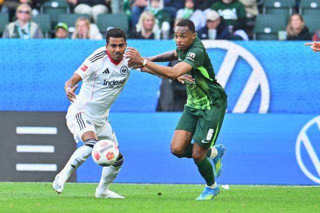 11 April 2026, Lower Saxony, Wolfsburg: Wolfsburg's Jeanuel Belocian (R) and Eintracht Frankfurt's Ansgar Knauff (L) battle for the ball during the German Bundesliga soccer match between VfL Wolfsburg and Eintracht Frankfurt at the Volkswagen Arena. Photo: Swen Pförtner/dpa - IMPORTANT NOTICE: DFL and DFB regulations prohibit any use of photographs as image sequences and/or quasi-video.