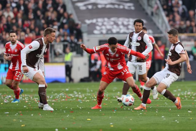 11 April 2026, Hamburg: Bayern Munich's Jamal Musiala (3rd R) and FC St. Pauli's Mathias Rasmussen (R) battle for the ball during the German Bundesliga soccer match between FC St. Pauli and Bayern Munich at Millerntor Stadium. Photo: Christian Charisius/dpa - IMPORTANT NOTICE: DFL and DFB regulations prohibit any use of photographs as image sequences and/or quasi-video.