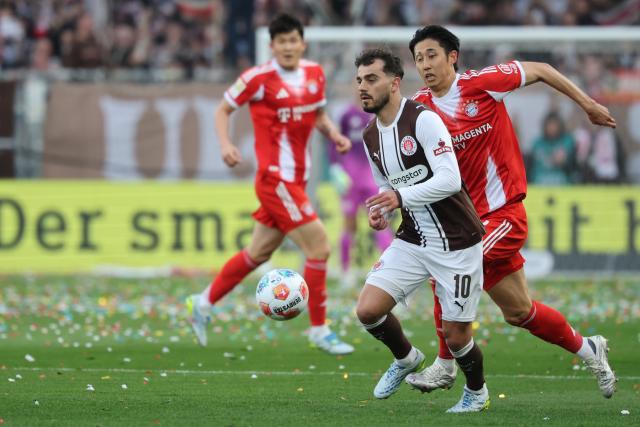 11 April 2026, Hamburg: St. Pauli's Danel Sinani and Bayern Munich's Hiroki Ito (R) battle for the ball during the German Bundesliga soccer match between FC St. Pauli and Bayern Munich at Millerntor Stadium. Photo: Christian Charisius/dpa - IMPORTANT NOTICE: DFL and DFB regulations prohibit any use of photographs as image sequences and/or quasi-video.