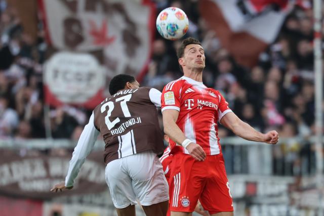 11 April 2026, Hamburg: Bayern Munich's Leon Goretzka and FC St. Pauli's Andreas Hountondji (L) battle for the ball during the German Bundesliga soccer match between FC St. Pauli and Bayern Munich at Millerntor Stadium. Photo: Christian Charisius/dpa - IMPORTANT NOTICE: DFL and DFB regulations prohibit any use of photographs as image sequences and/or quasi-video.