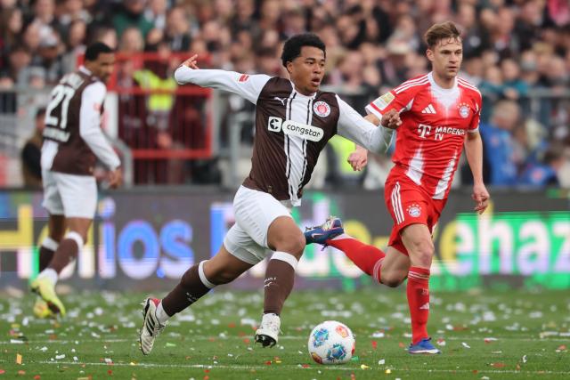 11 April 2026, Hamburg: St. Pauli's Joel Chima Fujita and Bayern Munich's Joshua Kimmich (R) battle for the ball during the German Bundesliga soccer match between FC St. Pauli and Bayern Munich at Millerntor Stadium. Photo: Christian Charisius/dpa - IMPORTANT NOTICE: DFL and DFB regulations prohibit any use of photographs as image sequences and/or quasi-video.