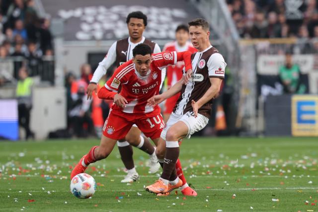 11 April 2026, Hamburg: Bayern Munich's Jamal Musiala in action against St. Pauli's Mathias Rasmussen during the German Bundesliga soccer match between FC St. Pauli and Bayern Munich at Millerntor Stadium. Photo: Christian Charisius/dpa - IMPORTANT NOTICE: DFL and DFB regulations prohibit any use of photographs as image sequences and/or quasi-video.