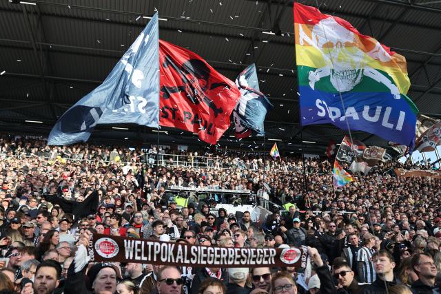 11 April 2026, Hamburg: St. Pauli fans waving flags in the stands during the German Bundesliga soccer match between FC St. Pauli and Bayern Munich at Millerntor Stadium. Photo: Christian Charisius/dpa - IMPORTANT NOTICE: DFL and DFB regulations prohibit any use of photographs as image sequences and/or quasi-video.