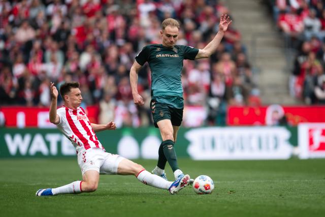 12 April 2026, North Rhine-Westphalia, Cologne: Cologne's Kristoffer Lund (L) and Werder Bremen's Amos Pieper battle for the ball during the German Bundesliga soccer match between 1. FC Cologne and Werder Bremen at RheinEnergieStadion. Photo: Marius Becker/dpa - WICHTIGER HINWEIS: Gemäß den Vorgaben der DFL Deutsche Fußball Liga bzw. des DFB Deutscher Fußball-Bund ist es untersagt, in dem Stadion und/oder vom Spiel angefertigte Fotoaufnahmen in Form von Sequenzbildern und/oder videoähnlichen Fotostrecken zu verwerten bzw. verwerten zu lassen.
