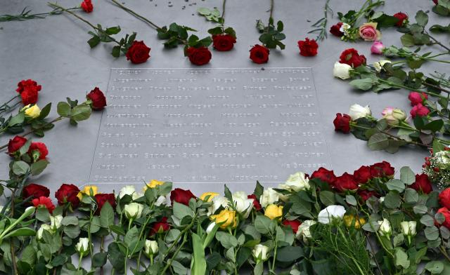 12 April 2026, Thuringia, Weimar: Flowers lie on a memorial plaque during the ceremony marking the 81st anniversary of the liberation of the Buchenwald concentration camp. Photo: Martin Schutt/dpa