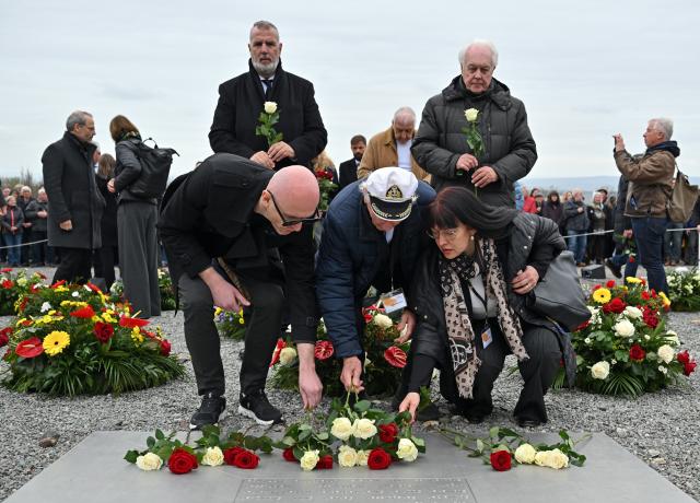 12 April 2026, Thuringia, Weimar: Andrej Moiseenko (C) from Belarus, a 99-year-old Buchenwald survivor, lays flowers during the ceremony marking the 81st anniversary of the liberation of the Buchenwald concentration camp. Photo: Martin Schutt/dpa