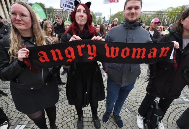 12 April 2026, Bavaria, Munich: People hold a scarf bearing the words "Angry Woman" at a rally organized by the Green Youth of Munich against sexual violence on Koenigsplatz under the slogan "Against patriarchal violence-for an end to oppression". Photo: Karl-Josef Hildenbrand/dpa
