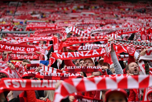 12 April 2026, Rhineland-Palatinate, Mainz: Mainz fans cheer in the stands prior to the start of the German Bundesliga soccer match between FSV Mainz 05 and SC Freiburg at Mewa Arena. Photo: Torsten Silz/dpa - WICHTIGER HINWEIS: Gemäß den Vorgaben der DFL Deutsche Fußball Liga bzw. des DFB Deutscher Fußball-Bund ist es untersagt, in dem Stadion und/oder vom Spiel angefertigte Fotoaufnahmen in Form von Sequenzbildern und/oder videoähnlichen Fotostrecken zu verwerten bzw. verwerten zu lassen.