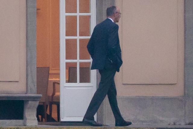 12 April 2026, Berlin: German Chancellor Friedrich Merz walks out onto the terrace in front of Villa Borsig during discussions among the leaders of the governing coalition regarding relief measures for energy prices and upcoming reforms. Photo: Carsten Koall/dpa
