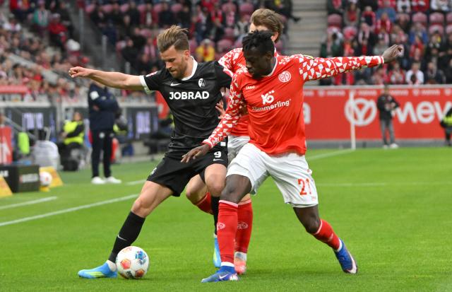 12 April 2026, Rhineland-Palatinate, Mainz: Mainz's Danny da Costa (R) and Freiburg's Lucas Hoeler battle for the ball during the German Bundesliga soccer match between FSV Mainz 05 and SC Freiburg at Mewa Arena. Photo: Torsten Silz/dpa - WICHTIGER HINWEIS: Gemäß den Vorgaben der DFL Deutsche Fußball Liga bzw. des DFB Deutscher Fußball-Bund ist es untersagt, in dem Stadion und/oder vom Spiel angefertigte Fotoaufnahmen in Form von Sequenzbildern und/oder videoähnlichen Fotostrecken zu verwerten bzw. verwerten zu lassen.