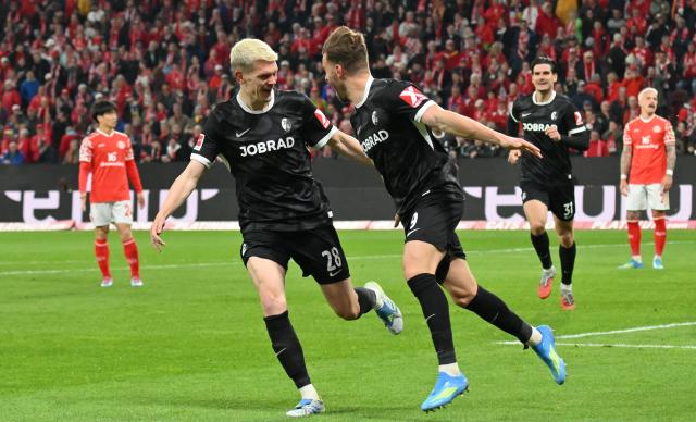 12 April 2026, Rhineland-Palatinate, Mainz: Freiburg's Lucas Hoeler (R) celebrates scoring his side's first goal with teammate Matthias Ginter during the German Bundesliga soccer match between FSV Mainz 05 and SC Freiburg at Mewa Arena. Photo: Torsten Silz/dpa - WICHTIGER HINWEIS: Gemäß den Vorgaben der DFL Deutsche Fußball Liga bzw. des DFB Deutscher Fußball-Bund ist es untersagt, in dem Stadion und/oder vom Spiel angefertigte Fotoaufnahmen in Form von Sequenzbildern und/oder videoähnlichen Fotostrecken zu verwerten bzw. verwerten zu lassen.