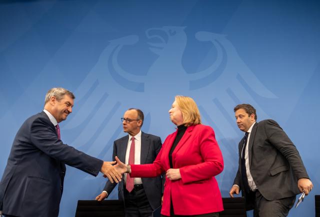 13 April 2026, Berlin: Markus Soeder (L-R), Minister President of Bavaria and CSU Chairman shakes hands with Baerbel Bas, German Minister of Labor and Co-Federal Chair of the SPD, in front of Federal Chancellor Friedrich Merz (CDU, M) and next to Lars Klingbeil (SPD,r), Federal Minister of Finance and Co-Federal Chair of the SPD, after the press conference following the Coalition Committee. Photo: Michael Kappeler/dpa