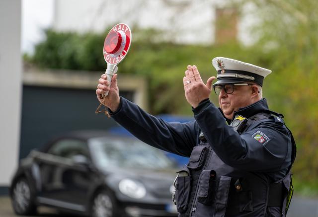 13 April 2026, North Rhine-Westphalia, Soest: A police officer "waves" a road user to a speed check on the Paderborner Landstrasse as part of the so-called "Speedweek". During the campaign week for greater road safety, which takes place nationwide, more speed checks are carried out. Photo: Max Lametz/dpa