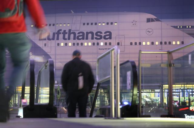 14 April 2026, Bavaria, Munich: People walk past a large image of a Lufthansa aircraft at Terminal 2 early in the morning on the second day of the pilots' strike. Photo: Karl-Josef Hildenbrand/dpa