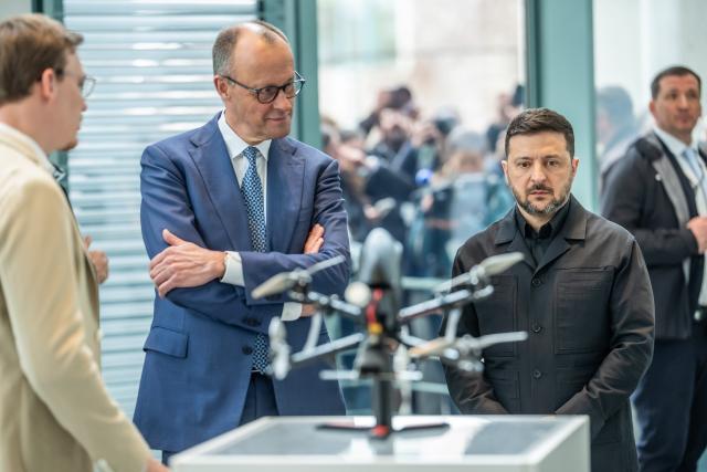 14 April 2026, Berlin: Friedrich Merz (C), Germany's Chancellor, inspects a drone alongside Volodymyr Zelensky (3rd R), President of Ukraine, at an exhibition of German-Ukrainian joint projects at the Federal Chancellery on the occasion of the German-Ukrainian government consultations. Photo: Michael Kappeler/dpa