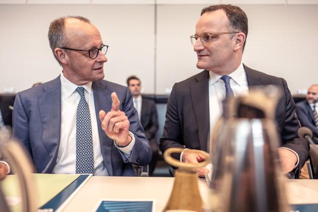 14 April 2026, Berlin: German Chancellor Friedrich Merz (L) speaks with Jens Spahn, CDU/CSU parliamentary group leader in the Bundestag, before the start of the parliamentary group meeting of the Chritsian Democratic Union/Christian Social Union (CDU/CSU) in the German Parliament Bundestag. Photo: Michael Kappeler/dpa