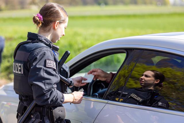 15 April 2026, Hesse, Gießen: Police officers check speeding offenders who have previously been flashed at the speed marathon checkpoint. As part of this year's speed marathon, speed checks are being carried out on the B457 between Fernwald and Giessen. Photo: Christian Lademann/dpa