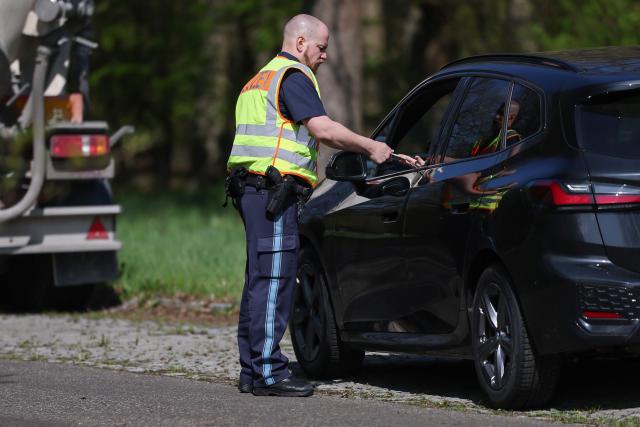 15 April 2026, Bavaria, Sulzheim-Alitzheim: A police officer from Gerolzhofen police station checks a driver in a parking lot on the B286 during the Bavaria-wide speed camera marathon. Photo: Daniel Löb/dpa
