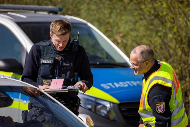 15 April 2026, Hesse, Gießen: Police officers check speeding offenders who have previously been flashed at the speed marathon checkpoint. As part of this year's speed marathon, speed checks are being carried out on the B457 between Fernwald and Giessen. Photo: Christian Lademann/dpa