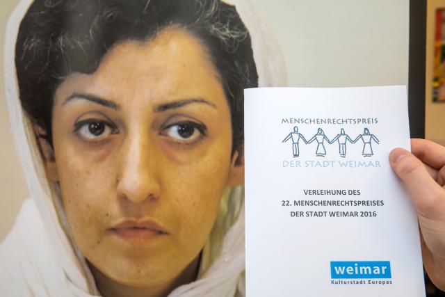 FILED - 10 December 2016, Thuringia, Weimar: A man holds the invitation to the event at a press conference during the award ceremony of the Weimar Human Rights Prize to Iranian activist Narges Mohammadi. Photo: -/dpa-Zentralbild/dpa