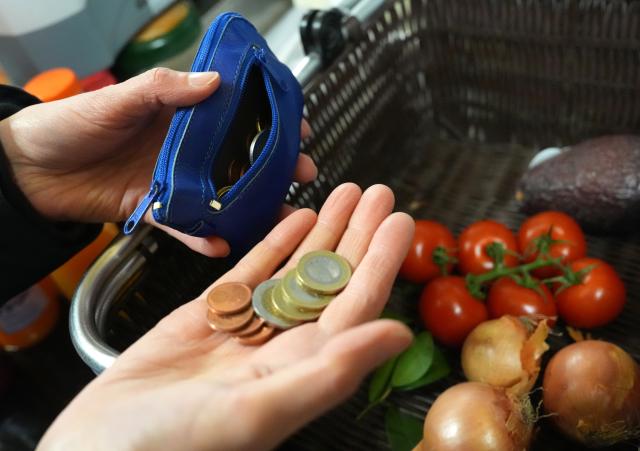 FILED - 05 January 2026, Hamburg: A woman pays for her purchase with cash at the checkout in a fruit and vegetable store. Photo: Marcus Brandt/dpa