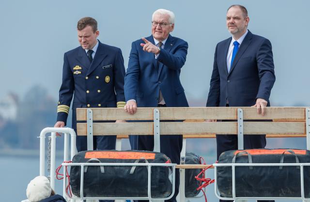 16 April 2026, Mecklenburg-Western Pomerania, Stralsund: Germany's President Frank-Walter Steinmeier (C) travels across the Strelasund on a naval vessel alongside Alexander Badrow (R), mayor of the Hanseatic City of Stralsund, and Commander Frank Richter, ahead of a visit to the Naval Technical School. As part of his 'Local Time Germany' tour, the Federal President is relocating his official residence to Stralsund until April 16. Photo: Jens Büttner/dpa