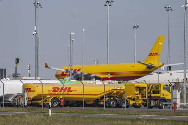 17 April 2026, Saxony, Schkeuditz: A DHL aircraft stands behind several tanker trucks at the DHL hub at Leipzig/Halle Airport. According to the aviation association BDL, the faltering supply of kerosene could soon lead to noticeable cuts in flight services. Photo: Jan Woitas/dpa