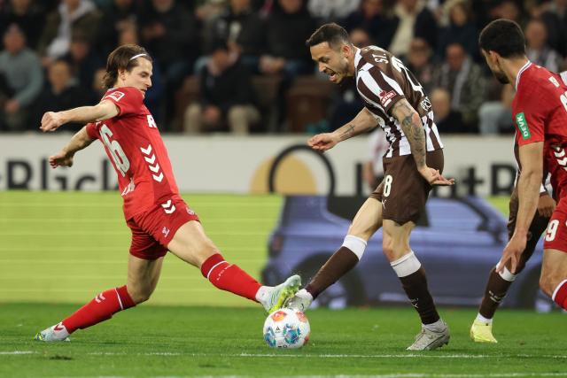 17 April 2026, Hamburg: Cologne's Jakub Kaminski (L) and St. Pauli's Mathias Pereira Lage battle for the ball during the German Bundesliga soccer match between FC St. Pauli and 1. FC Cologne at Millerntor Stadium. Photo: Christian Charisius/dpa - WICHTIGER HINWEIS: Gemäß den Vorgaben der DFL Deutsche Fußball Liga bzw. des DFB Deutscher Fußball-Bund ist es untersagt, in dem Stadion und/oder vom Spiel angefertigte Fotoaufnahmen in Form von Sequenzbildern und/oder videoähnlichen Fotostrecken zu verwerten bzw. verwerten zu lassen.