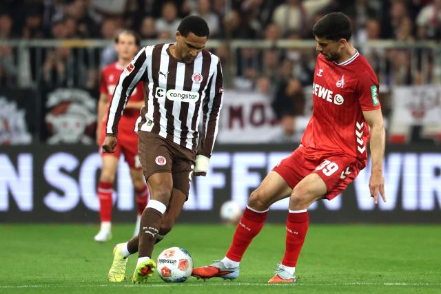 17 April 2026, Hamburg: Cologne's  Cenk Oezkacar (R) and St. Pauli's Andreas Hountondji battle for the ball during the German Bundesliga soccer match between FC St. Pauli and 1. FC Cologne at Millerntor Stadium. Photo: Christian Charisius/dpa - WICHTIGER HINWEIS: Gemäß den Vorgaben der DFL Deutsche Fußball Liga bzw. des DFB Deutscher Fußball-Bund ist es untersagt, in dem Stadion und/oder vom Spiel angefertigte Fotoaufnahmen in Form von Sequenzbildern und/oder videoähnlichen Fotostrecken zu verwerten bzw. verwerten zu lassen.