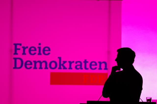 18 April 2026, North Rhine-Westphalia, Duisburg: During the speech by Henning Hoene, Chairman of the FDP in North Rhine-Westphalia, the lights in the hall go out and Höne stands in the dark at the lectern in front of an illuminated FDP banner. Photo: Christoph Reichwein/dpa