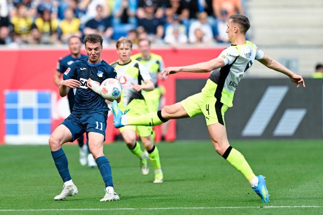18 April 2026, Baden-Wuerttemberg, Sinsheim: Borussia Dortmund's Nico Schlotterbeck (R) and Hoffenheim's Fisnik Asllani battle for the ball during the German Bundesliga soccer match between TSG 1899 Hoffenheim and Borussia Dortmund at PreZero Arena. Photo: Uwe Anspach/dpa - WICHTIGER HINWEIS: Gemäß den Vorgaben der DFL Deutsche Fußball Liga bzw. des DFB Deutscher Fußball-Bund ist es untersagt, in dem Stadion und/oder vom Spiel angefertigte Fotoaufnahmen in Form von Sequenzbildern und/oder videoähnlichen Fotostrecken zu verwerten bzw. verwerten zu lassen.