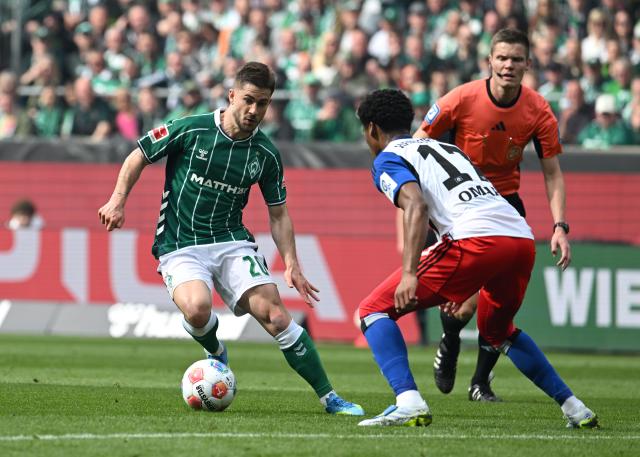 18 April 2026, Bremen: Werder Bremen's Romano Schmid (L) and Hamburger's Warmed Omari battle for the ball during the German Bundesliga soccer match between Werder Bremen and Hamburger SV at the Weserstadion. Photo: Carmen Jaspersen/dpa - WICHTIGER HINWEIS: Gemäß den Vorgaben der DFL Deutsche Fußball Liga bzw. des DFB Deutscher Fußball-Bund ist es untersagt, in dem Stadion und/oder vom Spiel angefertigte Fotoaufnahmen in Form von Sequenzbildern und/oder videoähnlichen Fotostrecken zu verwerten bzw. verwerten zu lassen.