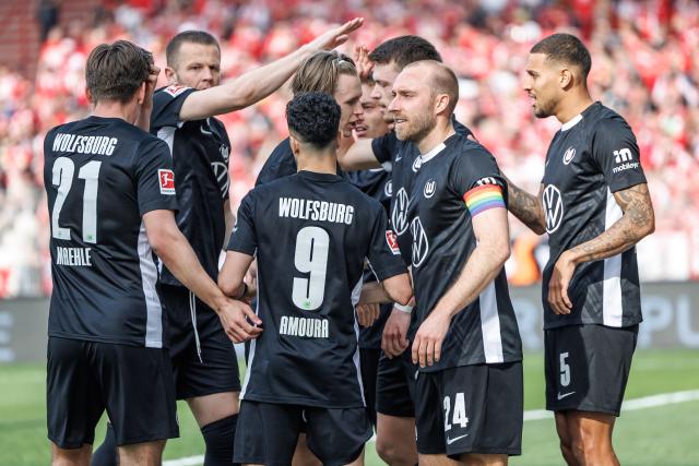 18 April 2026, Berlin: Wolfsburg players celebrate their side's second goal during the German Bundesliga soccer match between FC Union Berlin and VfL Wolfsburg at the Stadion An der Alten Foersterei. Photo: Andreas Gora/dpa - IMPORTANT NOTE: In accordance with the regulations of the DFL German Football League and the DFB German Football Association, it is prohibited to utilize or have utilized photographs taken in the stadium and/or of the match in the form of sequential images and/or video-like photo series.