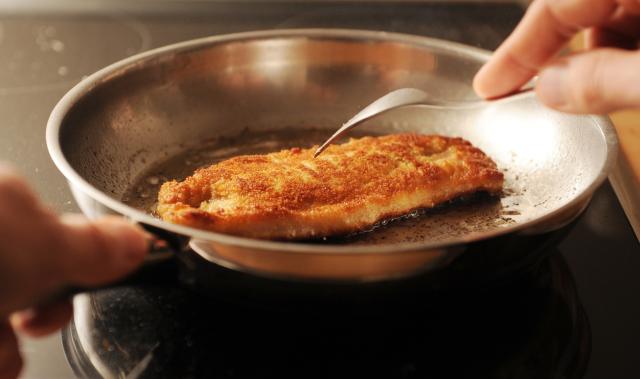 FILED - 23 October 2012, Hamburg: A person prepares Schnitzel on a stove in Hamburg. Police officers were called to settle a schnitzel-related dispute in southern Germany after a man assaulted his neighbour for allegedly pounding meat for the dish too loudly. Photo: Angelika Warmuth/dpa/dpa-tmn