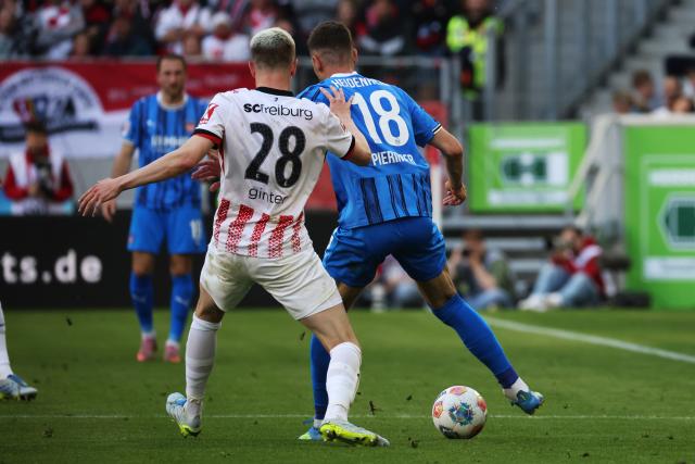 19 April 2026, Baden-Württemberg, Freiburg im Breisgau: Freiburg's Matthias Ginter (L) and Heidenheim's Marvin Pieringer (R) battle for the ball during the German Bundesliga soccer match between SC Freiburg and 1. FC Heidenheim at Europa-Park Stadium. Photo: Philipp von Ditfurth/dpa - WICHTIGER HINWEIS: Gemäß den Vorgaben der DFL Deutsche Fußball Liga bzw. des DFB Deutscher Fußball-Bund ist es untersagt, in dem Stadion und/oder vom Spiel angefertigte Fotoaufnahmen in Form von Sequenzbildern und/oder videoähnlichen Fotostrecken zu verwerten bzw. verwerten zu lassen.