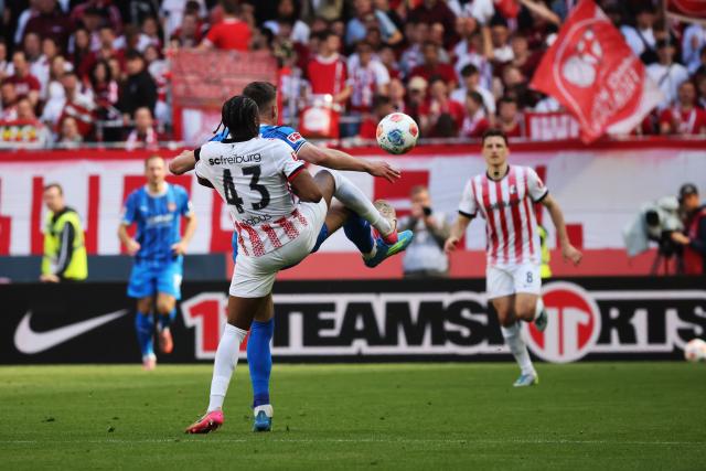 19 April 2026, Baden-Württemberg, Freiburg im Breisgau: Freiburg's Bruno Ogbus (L) and Heidenheim's Marvin Pieringer (R) battle for the ball during the German Bundesliga soccer match between SC Freiburg and 1. FC Heidenheim at Europa-Park Stadium. Photo: Philipp von Ditfurth/dpa - WICHTIGER HINWEIS: Gemäß den Vorgaben der DFL Deutsche Fußball Liga bzw. des DFB Deutscher Fußball-Bund ist es untersagt, in dem Stadion und/oder vom Spiel angefertigte Fotoaufnahmen in Form von Sequenzbildern und/oder videoähnlichen Fotostrecken zu verwerten bzw. verwerten zu lassen.