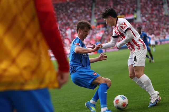19 April 2026, Baden-Württemberg, Freiburg im Breisgau: Heidenheim's Jan Schoeppner (L) and Freiburg's Yuito Suzuki (R) battle for the ball during the German Bundesliga soccer match between SC Freiburg and 1. FC Heidenheim at Europa-Park Stadium. Photo: Philipp von Ditfurth/dpa - WICHTIGER HINWEIS: Gemäß den Vorgaben der DFL Deutsche Fußball Liga bzw. des DFB Deutscher Fußball-Bund ist es untersagt, in dem Stadion und/oder vom Spiel angefertigte Fotoaufnahmen in Form von Sequenzbildern und/oder videoähnlichen Fotostrecken zu verwerten bzw. verwerten zu lassen.
