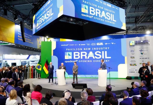 20 April 2026, Lower Saxony, Hanover: German Chancellor Friedrich Merz (R) and Brazil's President Luiz Inacio Lula da Silva (2nd L) speak at the Brazilian business stand during the opening tour of the Hannover Messe. Brazil is the partner country at this year's Hannover Messe. Photo: Moritz Frankenberg/dpa