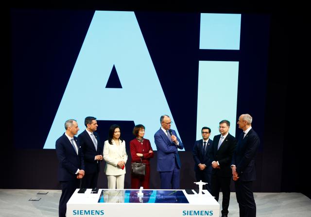 20 April 2026, Lower Saxony, Hanover: German Chancellor Friedrich Merz (C) stands next to his wife Charlotte Merz (4th L), Katherina Reiche (3rd L), Minister of Economics, and Olaf Lies (2nd L), Minister President of Lower Saxony, at the Siemens AG stand during the opening tour of the Hannover Messe. Brazil is the partner country at this year's Hannover Messe. Photo: Michael Matthey/dpa