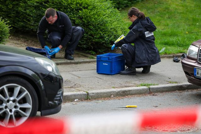 20 April 2026, North Rhine-Westphalia, Wuppertal: Forensic officers from the KTU collect evidence at the crime scene as a possible murder weapon, a knife, lies on the street in Wuppertal. A man attacked and Photo: Christoph Reichwein/dpa