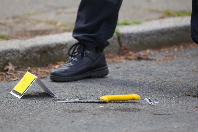 20 April 2026, North Rhine-Westphalia, Wuppertal: Forensic officers from the KTU collect evidence at the crime scene as a possible murder weapon, a knife, lies on the street in Wuppertal. A man attacked and Photo: Christoph Reichwein/dpa
