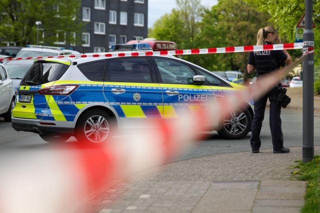 20 April 2026, North Rhine-Westphalia, Wuppertal: Forensic officers from the KTU collect evidence at the crime scene as a possible murder weapon, a knife, lies on the street in Wuppertal. A man attacked and Photo: Christoph Reichwein/dpa