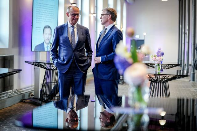 20 April 2026, Berlin: Christian Sewing (R), President of the Association of German Banks, welcomes Friedrich Merz (C), Germany's Chancellor, at the annual reception marking the 75th anniversary of the Association of German Banks. Photo: Kay Nietfeld/dpa