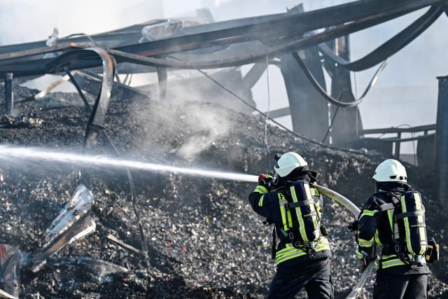 20 April 2026, Rhineland-Palatinate, Lustadt: Firefighters extinguish a fire in the warehouse of a recycling company. Photo: Uwe Anspach/dpa