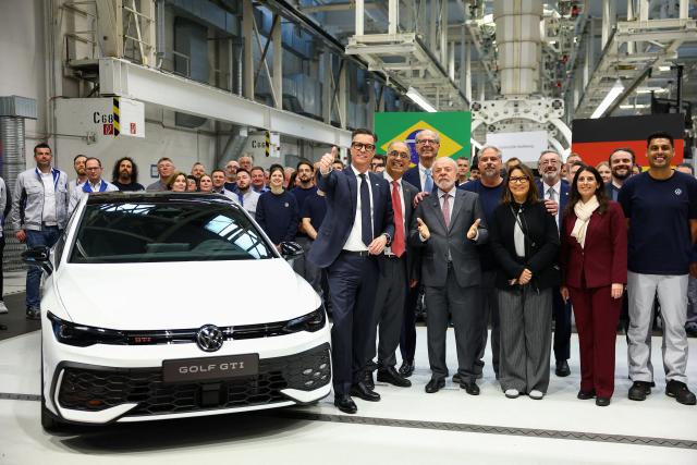 20 April 2026, Wolfsburg: Brazilian President Luiz Inácio Lula da Silva (4th R) and his wife Rosângela da Silva ('Janja') (3rd R) pose for a group photo with Volkswagen employees next to a Volkswagen Golf GTI during a visit to the Volkswagen plant in Wolfsburg. Photo: Lisi Niesner/Pool Reuters/dpa