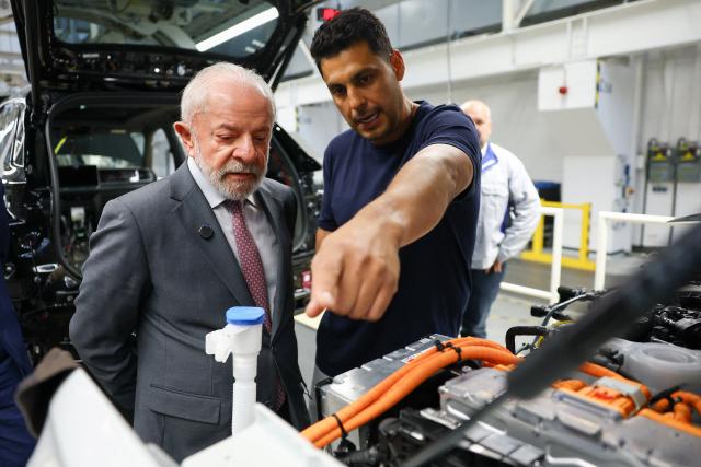 20 April 2026, Wolfsburg: Volkswagen employee Marcelo Reis (R) shows Luiz Inacio Lula da Silva, Brazil's President, the assembly line at the Volkswagen plant in Wolfsburg. Photo: Lisi Niesner/Pool Reuters/dpa