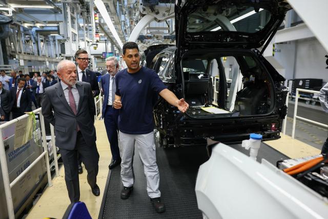 20 April 2026, Wolfsburg: Volkswagen employee Marcelo Reis (R) shows Luiz Inacio Lula da Silva, Brazil's President, the assembly line at the Volkswagen plant in Wolfsburg. Photo: Lisi Niesner/Pool Reuters/dpa