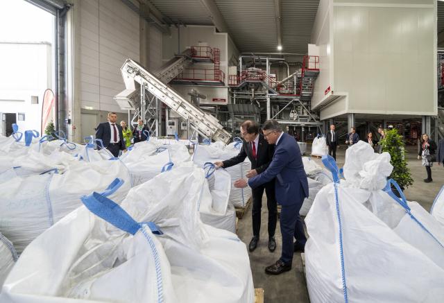 21 April 2026, Hesse, Ginsheim-Gustavsburg: Hans Roth (L), founder of "Saubermacher AG," and Minister-President of Hesse Boris Rhein stand among "big bags" containing batteries for the recycling process at the battery recycling plant. Photo: Andreas Arnold/dpa