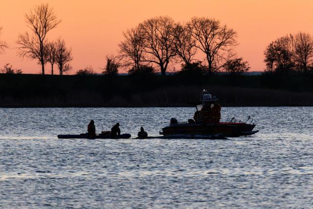 21 April 2026, Mecklenburg-Western Pomerania, Kirchdorf (Poel): Rescuers work next to the whale. The humpback whale has not moved from its position in the shallow water. Photo: Marcus Golejewski/dpa